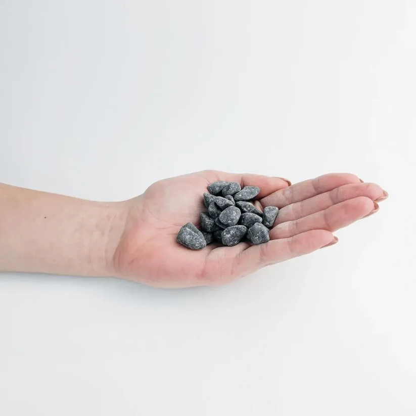 Small dark grey black basalt chippings in a palm