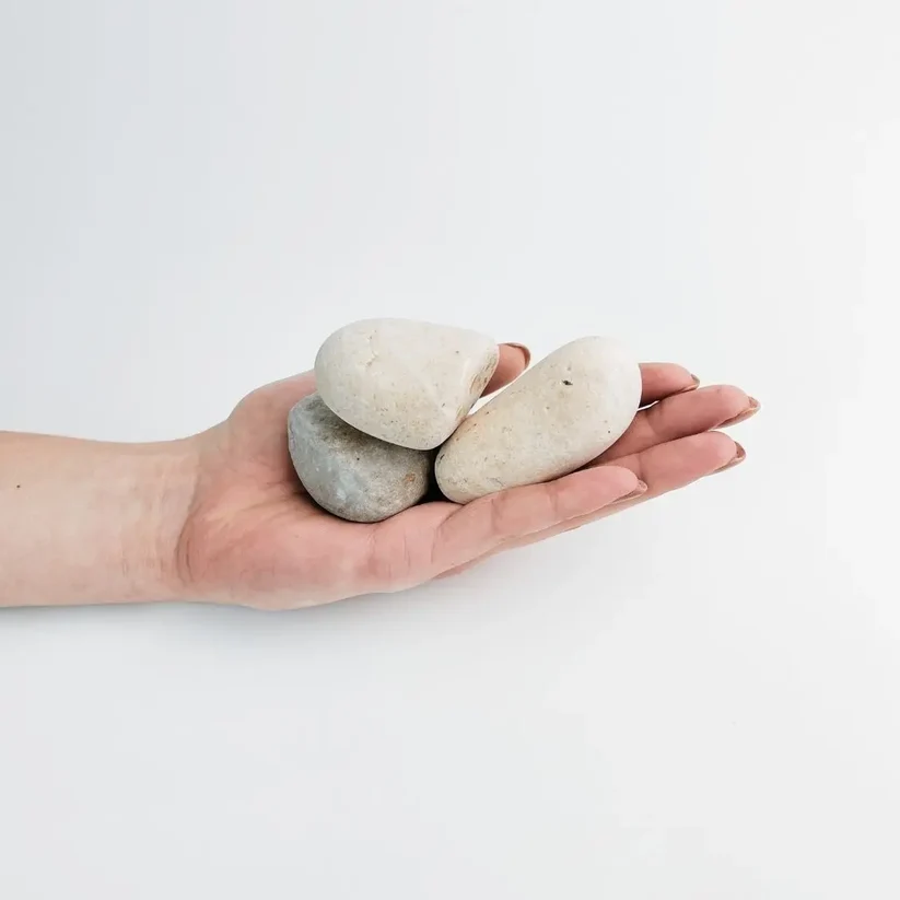 Large cream and pale grey umber porto pebbles in a hand